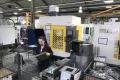 Media Name: machine_operator_running_cell_of_two_fanuc_machines.jpg
