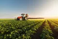 uk agriculture boom, tractor spraying soybean field.