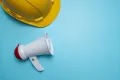 PR analytics engineering concept megaphone and hard hat on blue background