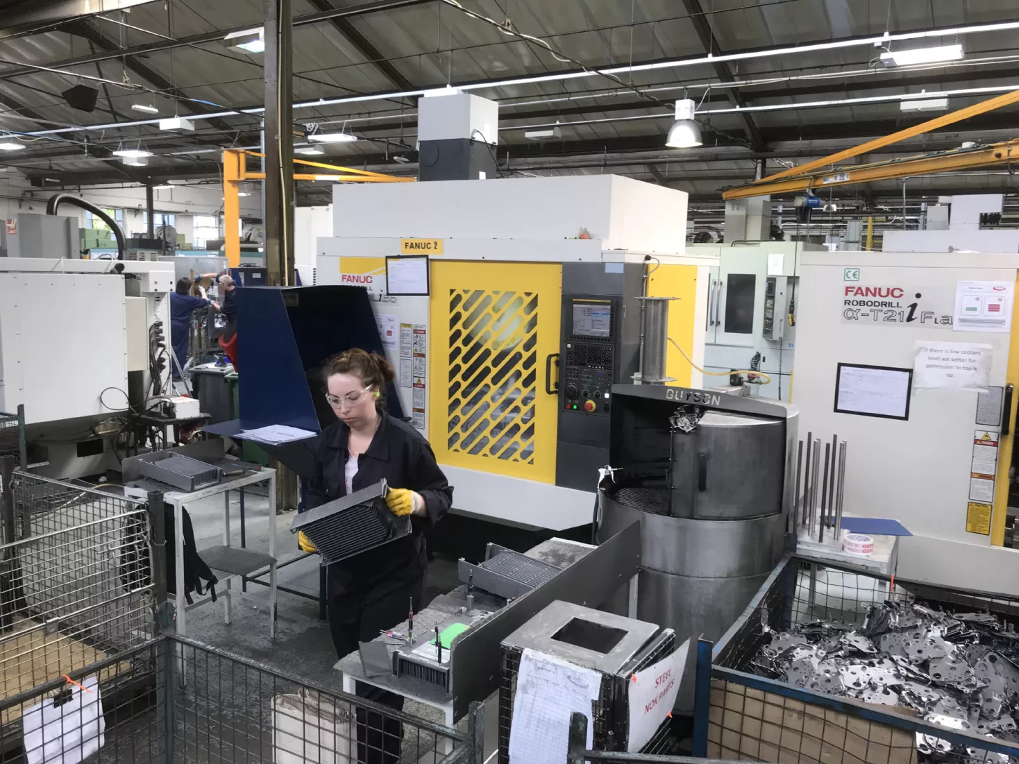 Media Name: machine_operator_running_cell_of_two_fanuc_machines.jpg
