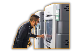 This is an image of a 3D printing machine being operated by a additive manufacturing specialist - typical of a Qimtek supplier member