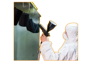 This is an image of a lady powder coating components in a booth - a typical service Qimtek members can provide