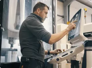 This is an image of an engineer working at Rotec Engineering programming a CNC machine 