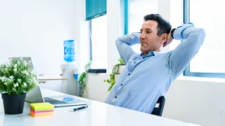 Buyer relaxed at their desk after sourcing custom manufacturing work easily using the Qimtek platform